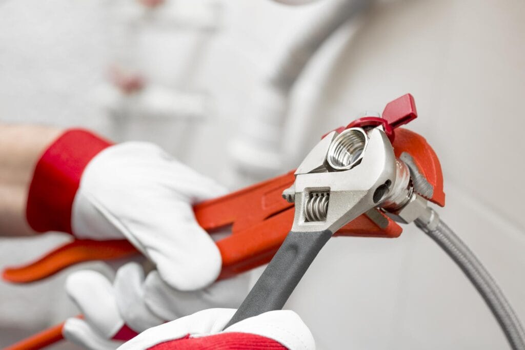 Plumber holding pipe wrenches for an emergency repair in Pinellas Park