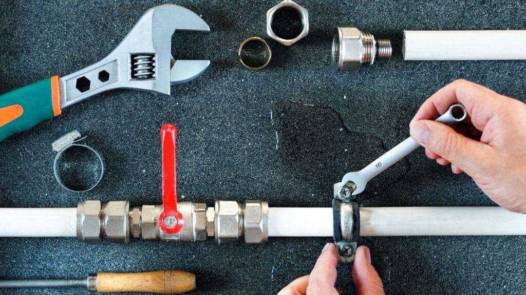 Plumber repairing a pipe valve with an adjustable wrench in Pinellas Park
