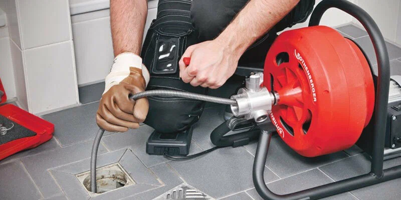 Plumber using a drain-cleaning machine in Pinellas Park