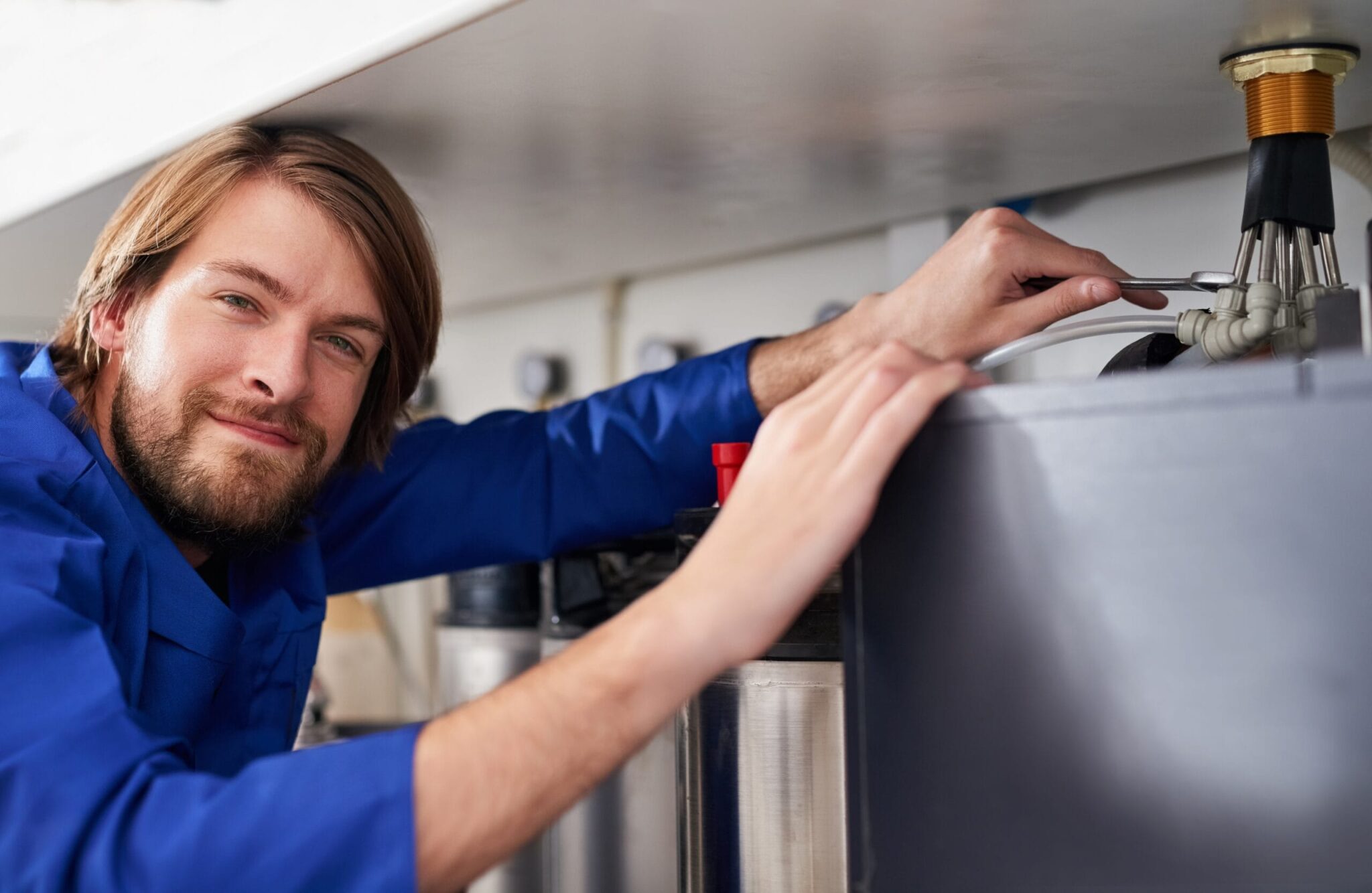 Technician servicing a residential water heater tank in Pinellas Park