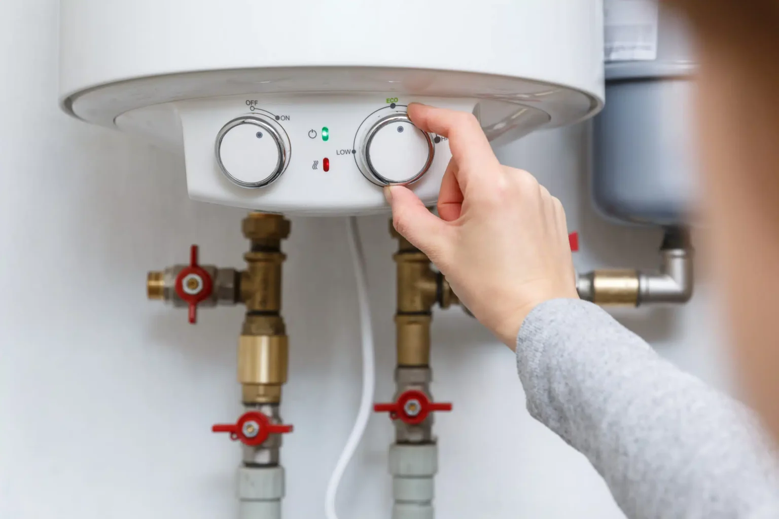 Homeowner adjusting the temperature controls on a water heater in Pinellas Park